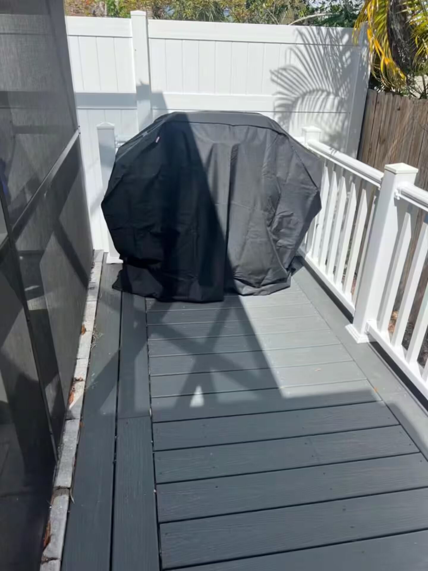 Una terraza techada con barandal blanco.