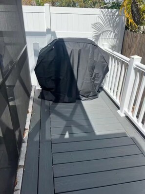 Een overdekt terras buiten, met een witte balustrade.