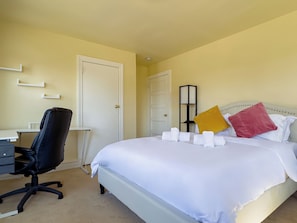 A hotel room with a bed, a desk, and a chair. - Entire Suburban 7BR Home 20 Mins to Philly (Upper Darby)