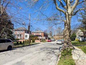 A residential street with houses, parked cars, and a sidewalk. - Entire Suburban 7BR Home 20 Mins to Philly (Upper Darby)