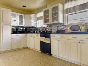 A kitchen with white cabinets, a microwave, and a dishwasher.