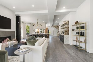 A modern living room with a fireplace, a sofa, a coffee table, and a bookshelf.