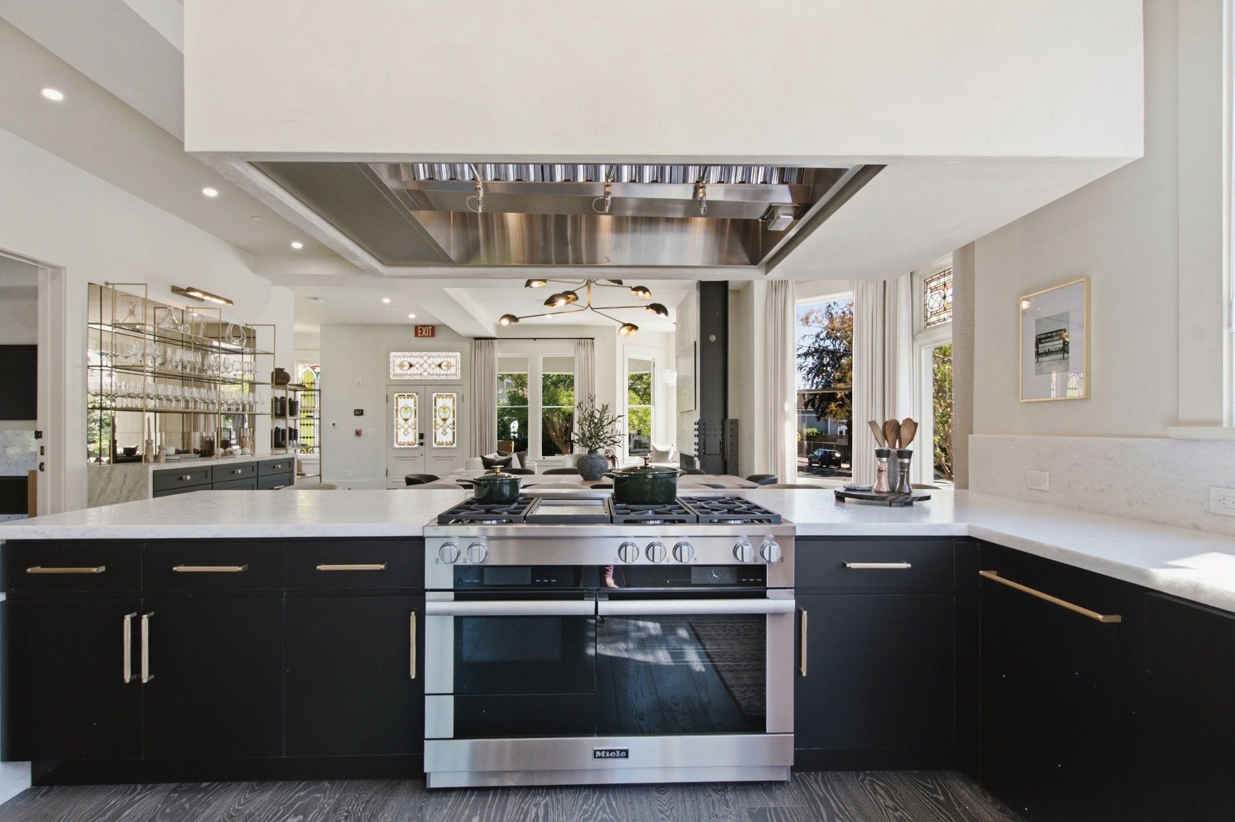 A modern kitchen with a central island, stainless steel appliances, and a view to the outdoors.