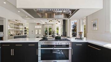 A modern kitchen with a central island, stainless steel appliances, and a view to the outdoors.