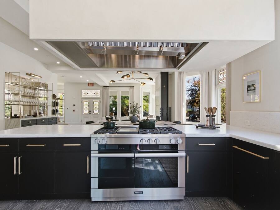 A modern kitchen with a central island, stainless steel appliances, and a view to the outdoors.