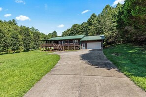 A two-story log cabin with a covered porch and a garage. - Hiker’s Hideaway | Hot Tub • Games • Dog Friendly (Suches)