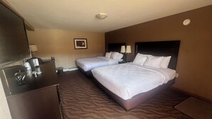 Een hotelkamer met twee bedden, een bureau en een stoel.