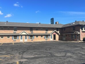 A multi-story building with a parking lot in front. - the DL hotel (Detroit Lakes)