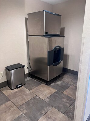 A stainless steel refrigerator with a freezer compartment, a water dispenser, and a trash bin. - the DL hotel (Detroit Lakes)