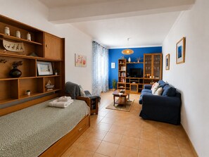 Ein kompakter Wohnbereich mit Bett, Sofa, Fernsehtisch und Essplatz.