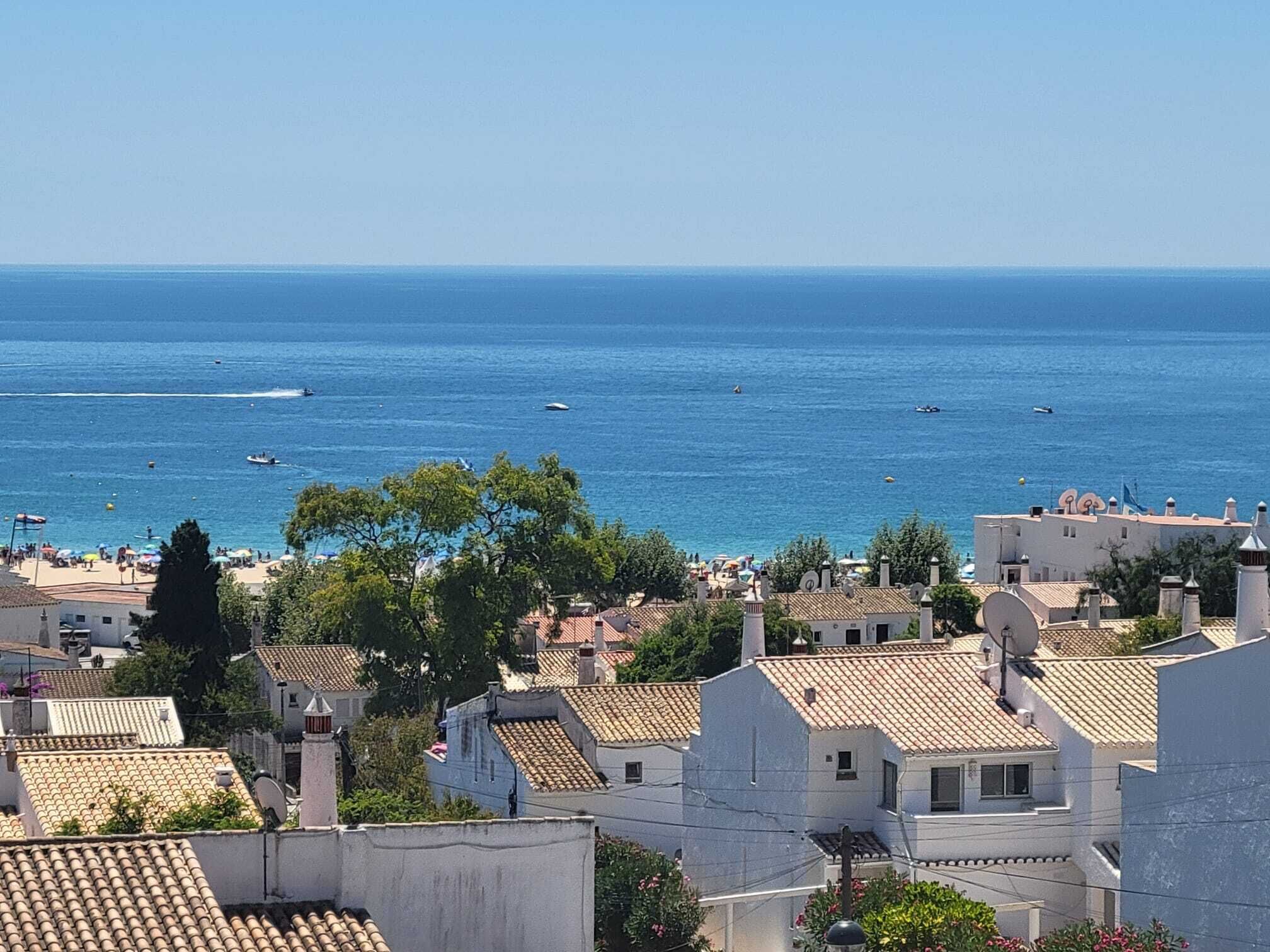 A coastal town with buildings, a beach, and boats on the water.
