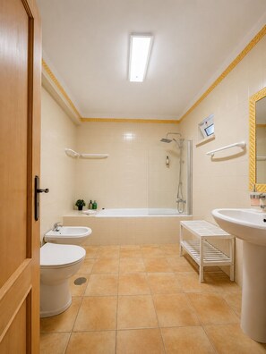 Ein Badezimmer mit Toilette, Bidet, Badewanne und Waschbecken.