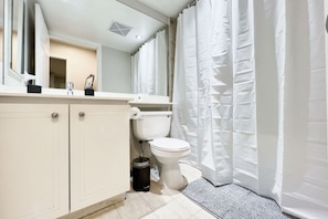 Ein Badezimmer mit Toilette, Waschbecken und Spiegel.