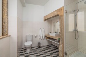Een moderne badkamer met toilet, wastafel en douche.
