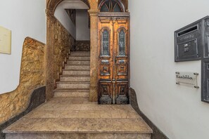 A staircase leading to a wooden door with a sign above it. - Vintage-Chic Apartment in the City Center, Chiado (Lisboa)