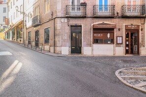 Een straatbeeld met een gebouw met daarin een restaurant genaamd 'DUQUE' en een ander genaamd 'COZINHA PORTUGUESA E MEDITERRÂNICA'.