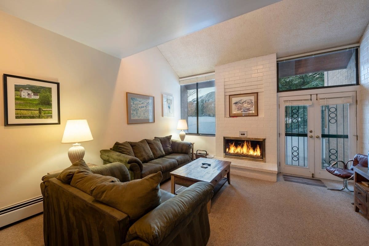 A living room with a fireplace, leather sofa, and a coffee table.