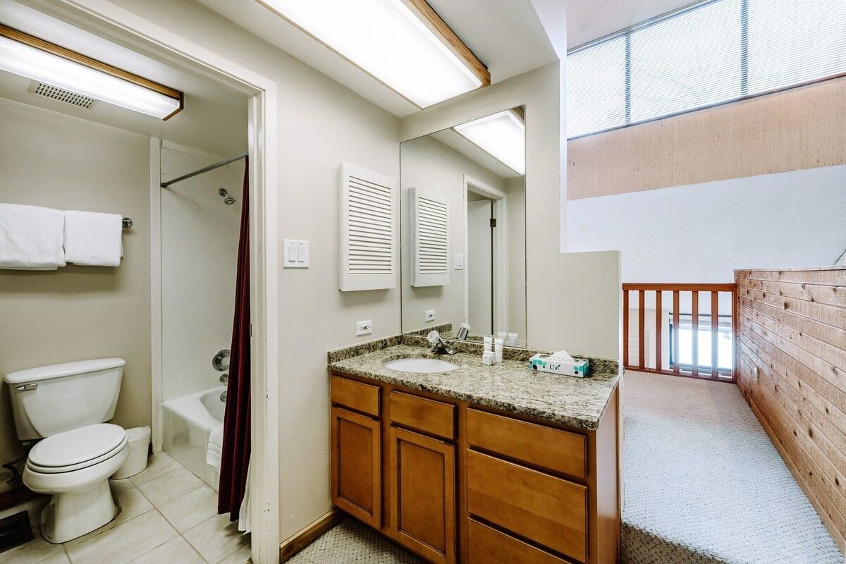 Un baño con inodoro, lavabo y ducha.
