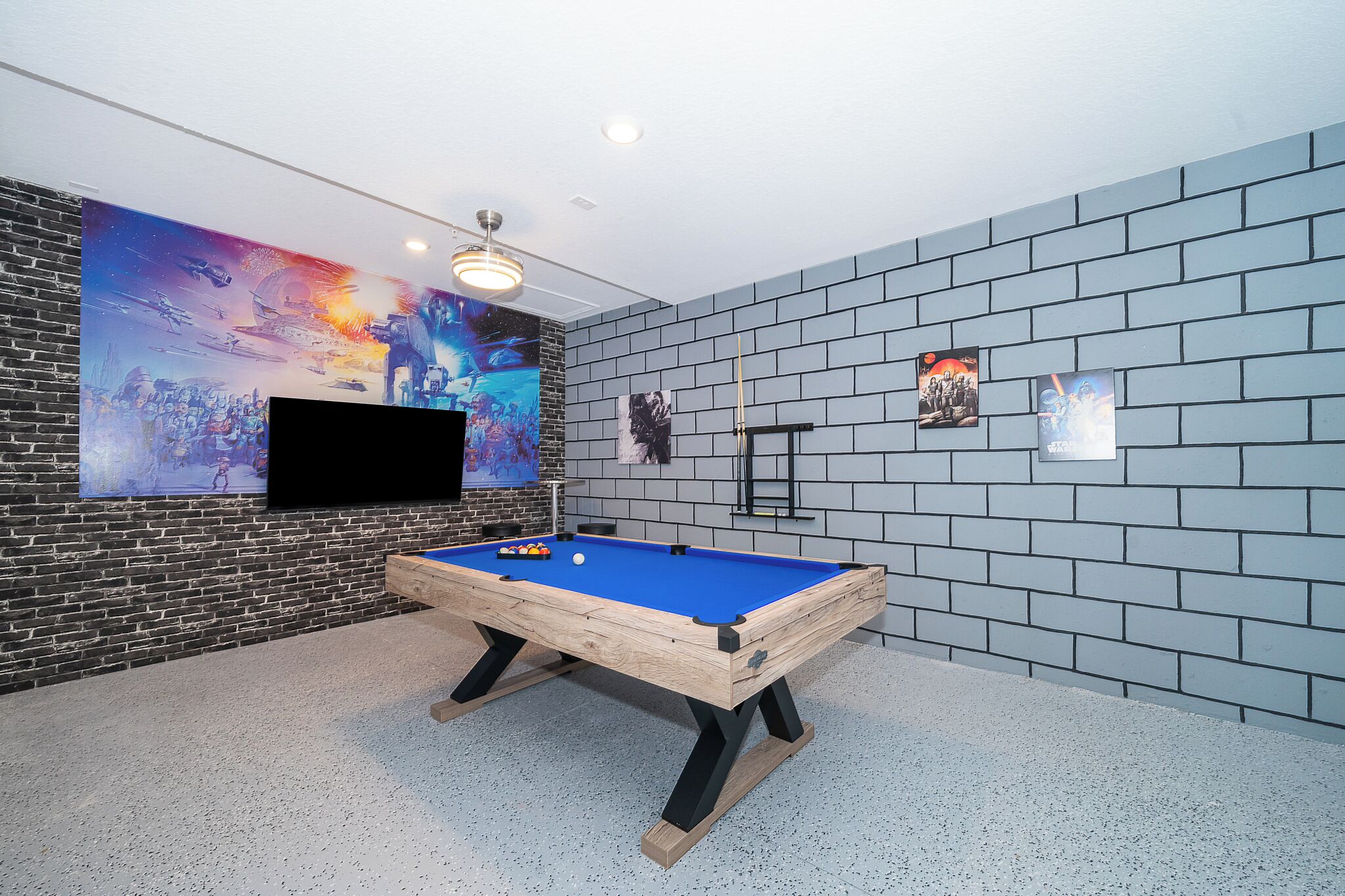 A pool table in a room with a brick wall and a large mural.