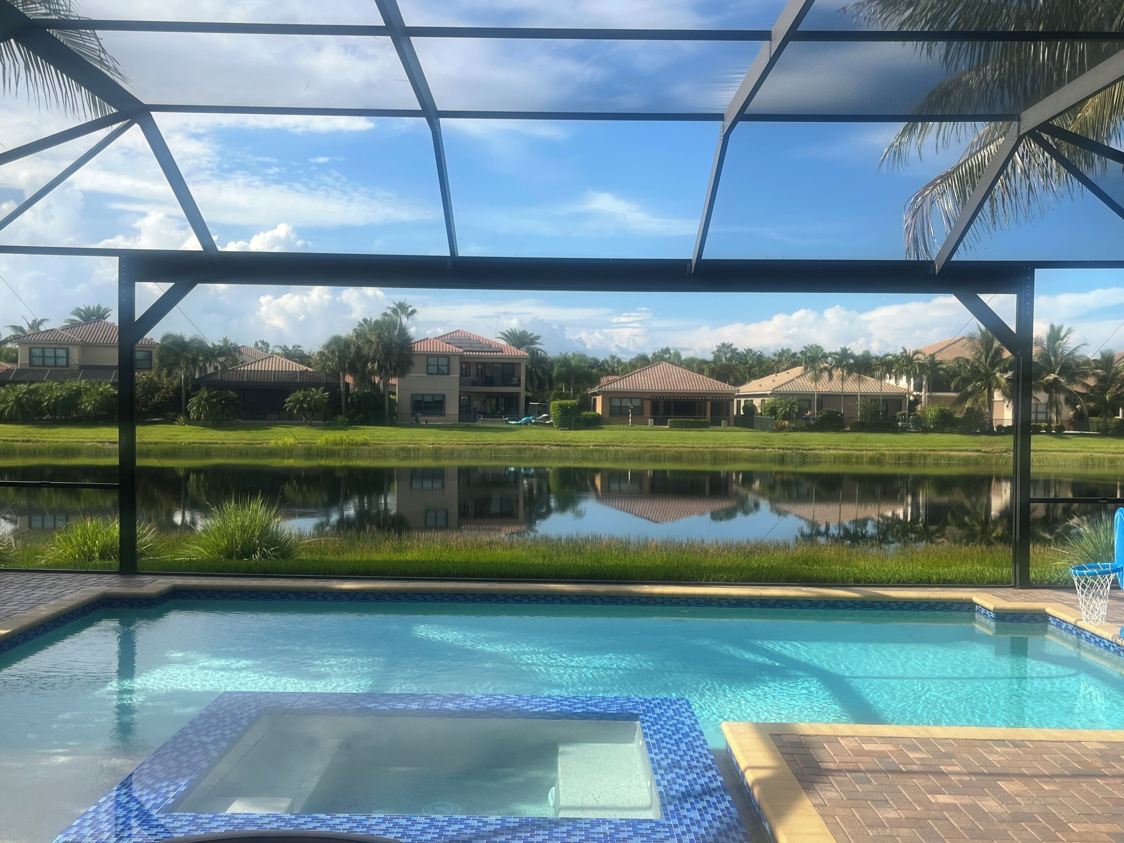 Ein Poolbereich mit Blick auf einen Wohnkomplex und einen Teich.