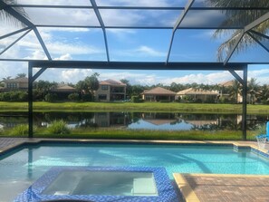 A pool area with a view of a residential complex and a pond. - Charming house in Naples perfect for a relaxing getaway (Naples)