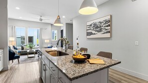 A modern kitchen with granite countertops, a built-in sink, and pendant lighting. - Harmony House by Avantstay Sunlit Open Design + Island Kitchen Five Points + Broadway (Nashville)