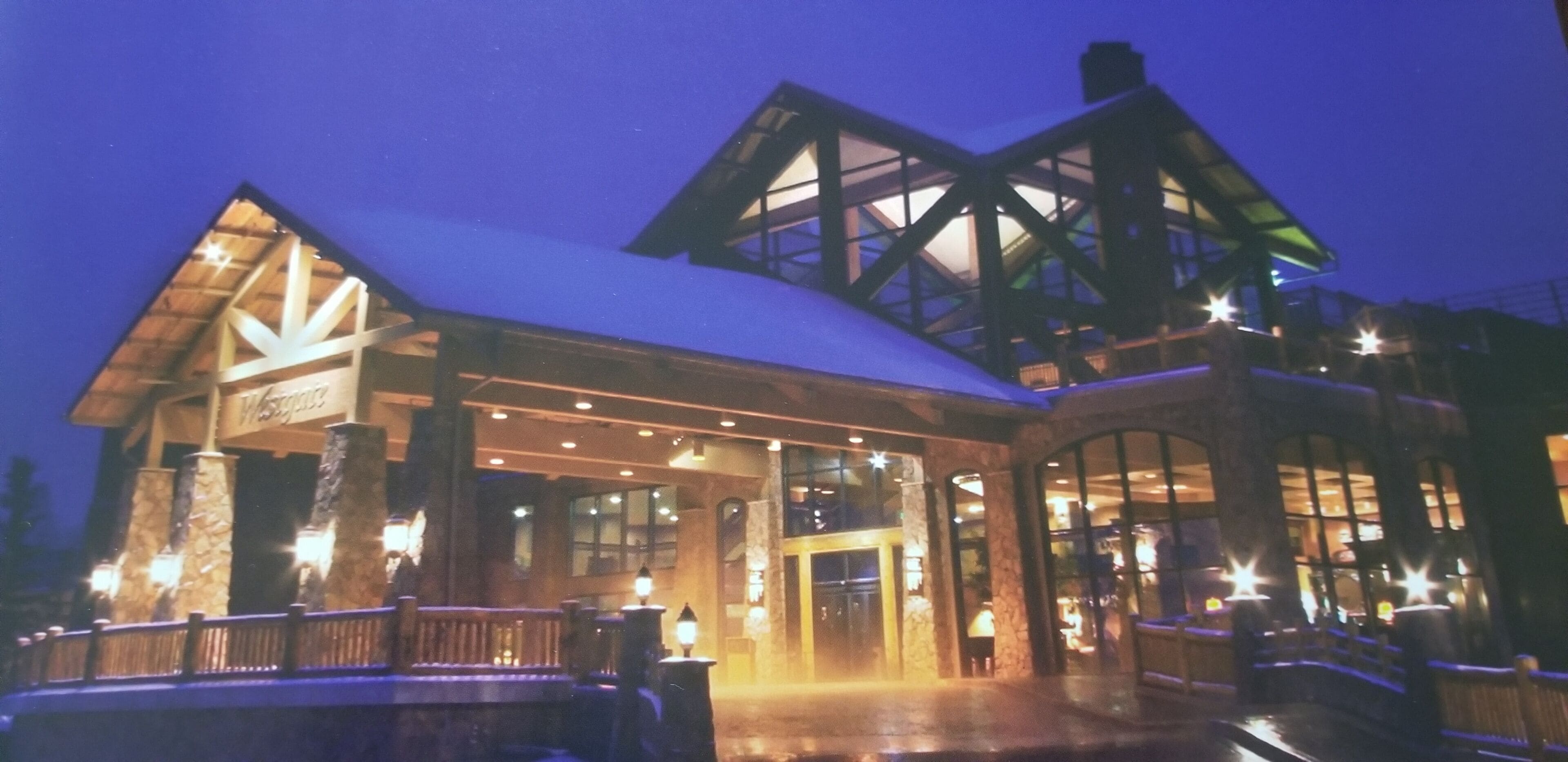 Ein Chalet mit großem Eingang, Steinsäulen und einem überdachten Gang.