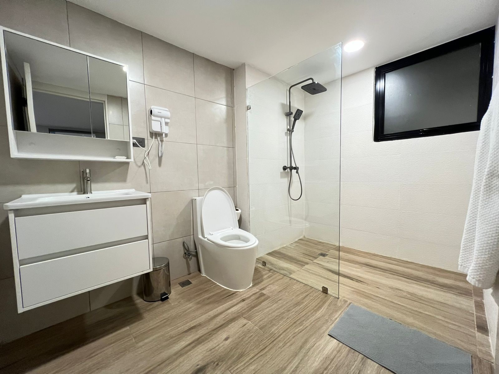 Casa de banho moderna com sanita, lavatório e chuveiro.