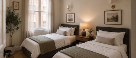 A hotel room with two beds, a nightstand with a lamp, a potted plant, and a window with curtains.