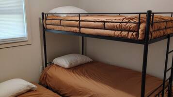 A bunk bed room with a window and a ceiling vent.