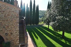 A stone building with a paved pathway leading to a well-manicured lawn. - Private Tuscan Wine Estate with 3 Houses and Sweeping Views of the Chianti Hills (Toscana)