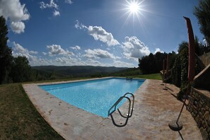 A rectangular swimming pool with clear blue water, surrounded by a stone patio. - Private Tuscan Wine Estate with 3 Houses and Sweeping Views of the Chianti Hills (Toscana)