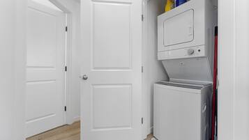Une buanderie avec une porte blanche, un lave-linge et un sèche-linge.