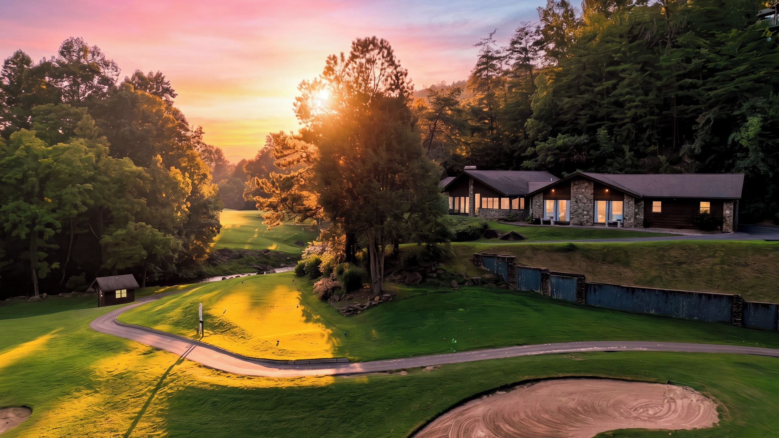 Een golfbaan met een clubhuis, een verzorgd gazon en een heldere lucht.