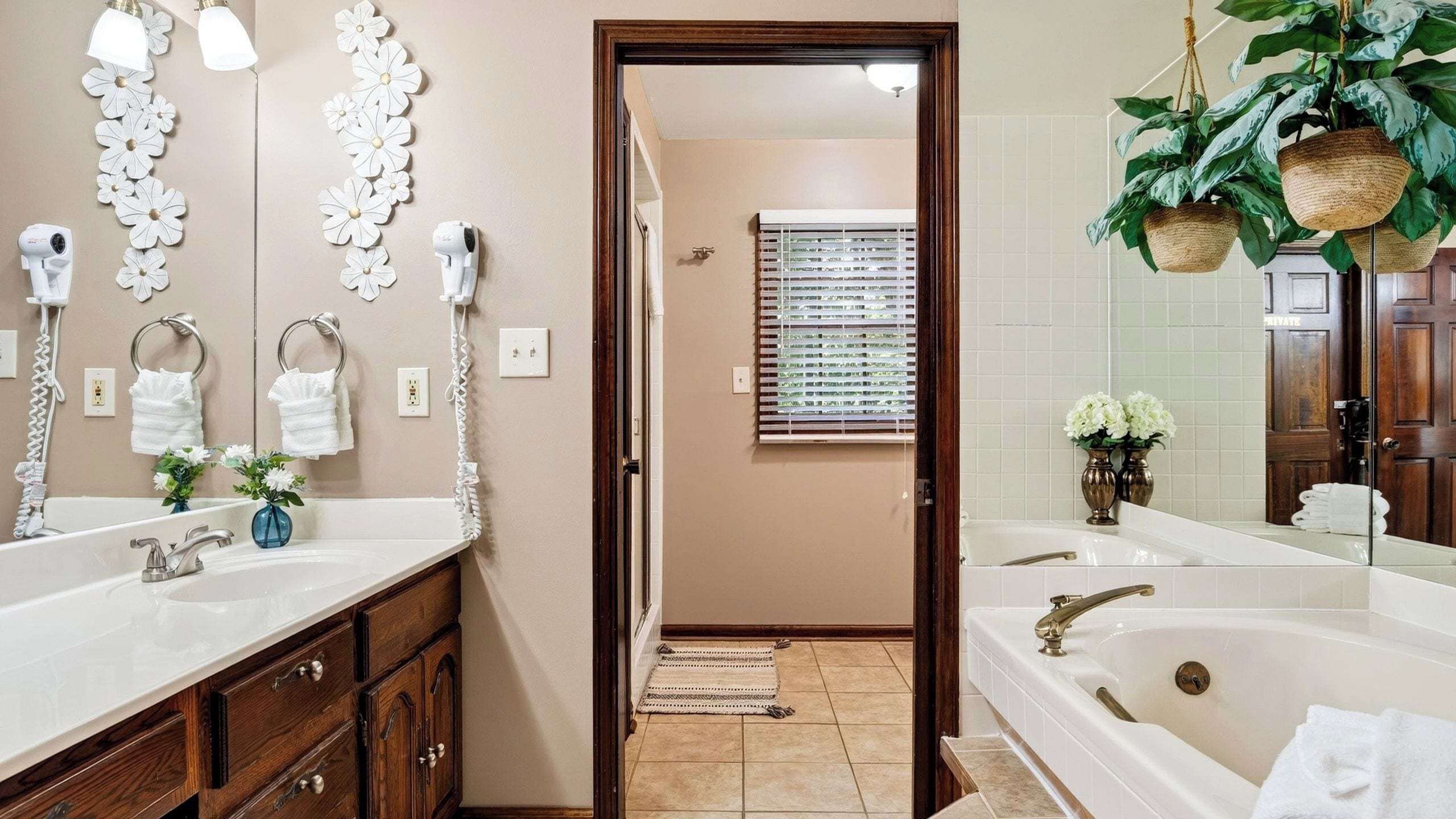 Un baño con dos lavamanos, un espejo y una ventana con persianas.