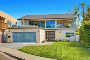 A two-story house with a garage, a balcony, and a well-maintained lawn. - Calumet Luxury Paradise  – A Sophisticated La Jolla Retreat (San Diego)