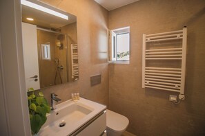 Ein modernes Badezimmer mit Waschbecken, Spiegel und Handtuchhalter.