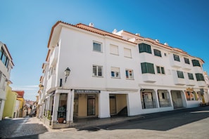 A white building with a storefront labeled 'UNIQ ARTEFACTS' on the ground floor. - 188 Apartments - Orquídea (City Center and Ocean View) (Cascais)