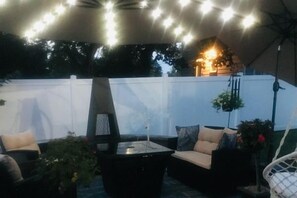 An outdoor patio area with a sofa set, a table, and a hanging chair. - Private Estate | Historic Home + Industrial Studio (Uniontown)