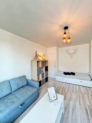 Ein modernes Wohnzimmer mit einem grauen Sofa, einem weißen Couchtisch und einer integrierten Regallösung.