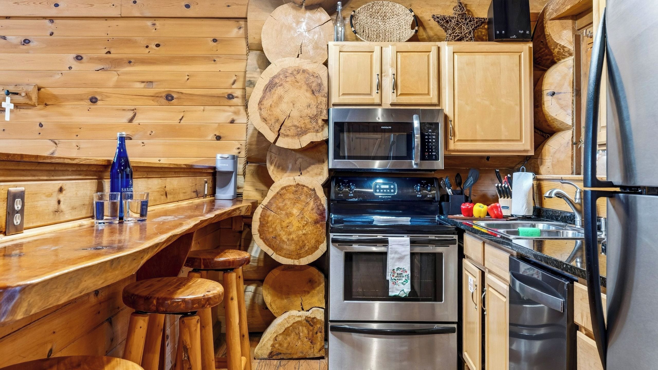 Eine Küche mit Holzschränken, einer Mikrowelle, einem Backofen und einem Kühlschrank.