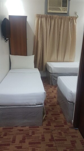 A room with two beds, a wardrobe, a curtain, and a wall-mounted air conditioner. - Maather Elite Hotel (Makkah)