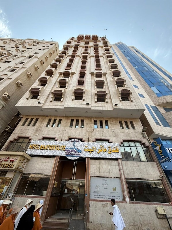 A hotel with a prominent sign, multiple floors, and a modern glass facade. - Maather Elite Hotel (Makkah)