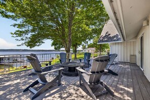 A deck with outdoor furniture, a view of a body of water, and a tree. - The Ranch of Monkey Island [Private Dock] (Afton)