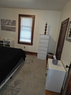 A bedroom with a bed, dresser, window, and artwork on the wall. - Perfect 2-bedroom house, walk downtown Appleton or Packer stadium 30 min drive (Appleton)