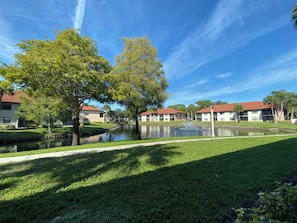 Área residencial com lago, gramados verdes e edifícios com telhados vermelhos.