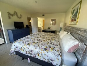 A bedroom with a bed, a dresser, a television, and a door leading to another room. - Groud floor  condo in pleasant Bradenton with water view (Bradenton)