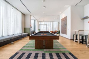 A modern living room with a pool table, a sofa, and a dining area. - The Crosby Miami Studio by Palermo Home (Miami)