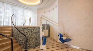 A hotel bathroom with a tiled floor, a shower area, and a handrail. - The Crosby Miami Studio by Palermo Home (Miami)