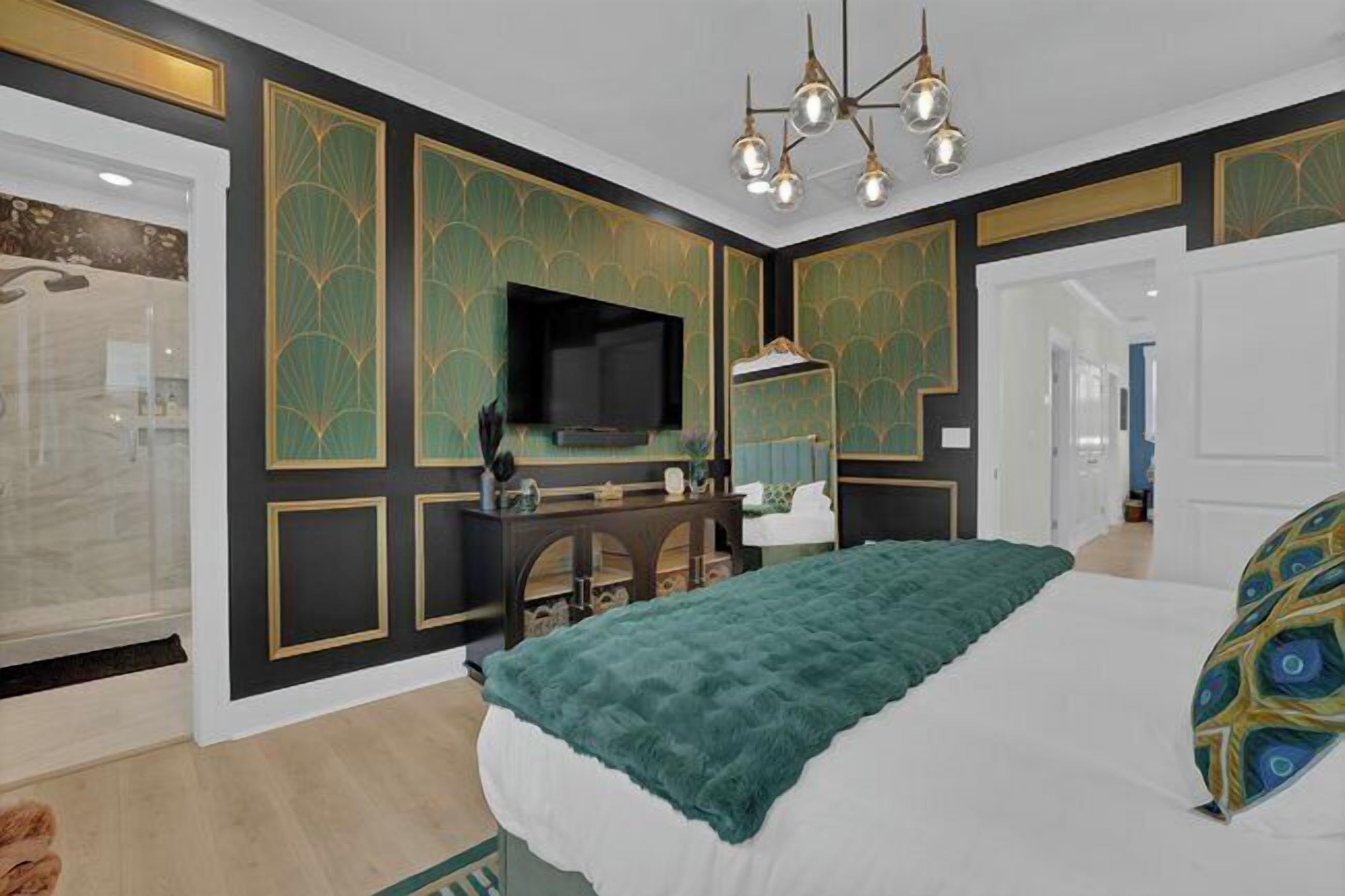 Ein Schlafzimmer mit einem Bett, einem Fernseher, einem Schminktisch und einem Spiegel.